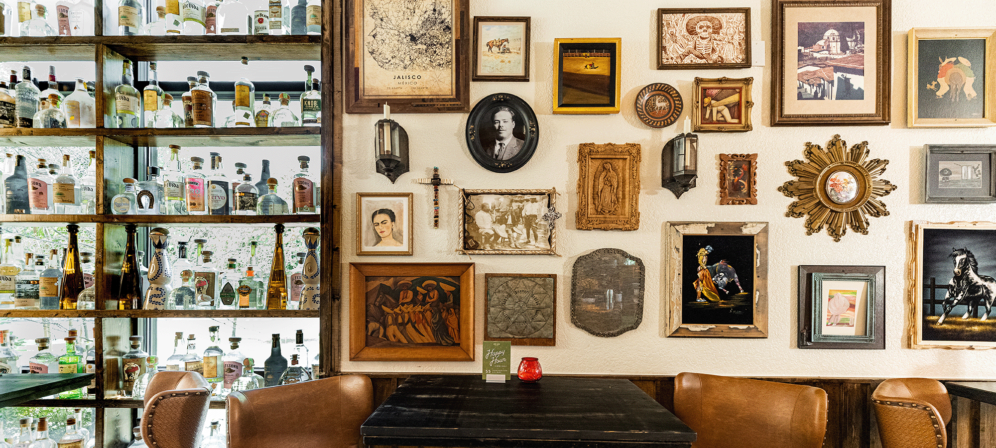 A wall of decorative frames hang above a bar table.